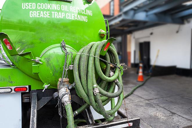 a technician pumping a grease trap in a commercial building in Daly City, CA